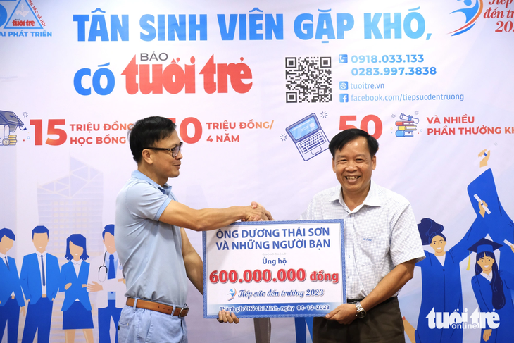 Ông Dương Thái Sơn - giám đốc Công ty TNHH bao bì giấy Nam Long (phải) - đến báo Tuổi Trẻ trao khoản đóng góp của ông và bạn bè, đồng nghiệp cho chương trình "Tiếp sức đến trường" - Ảnh: VŨ THỦY