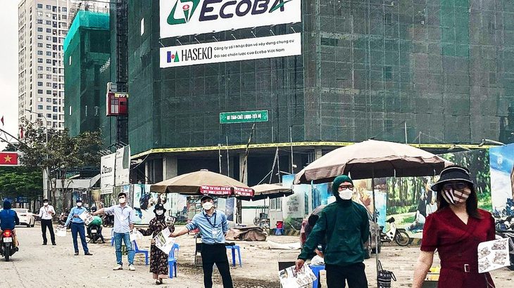 Nhân viên môi giới nhà đất xuống đường mời chào khách hàng mua chung cư tại một dự án đang mở bán ở huyện Hoài Đức, Hà Nội - Ảnh: QUANG THẾ