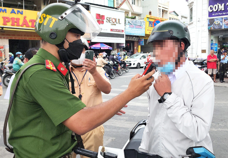 Lực lượng công an kiểm tra nồng độ cồn người tham gia giao thông - Ảnh: MINH HÒA
